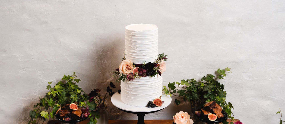 Two tiered wedding cake with fresh flowers and fresh berries